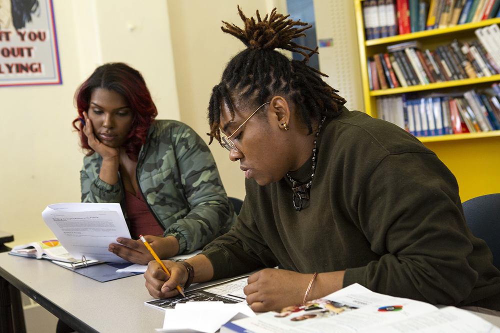 A non-binary and transfeminine high school students working on homework together in a classroom. Photo credit: The Gender Spectrum Collection