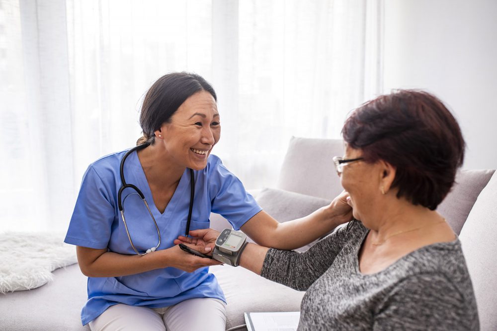 A happy nurse taking her patients blood pressure
