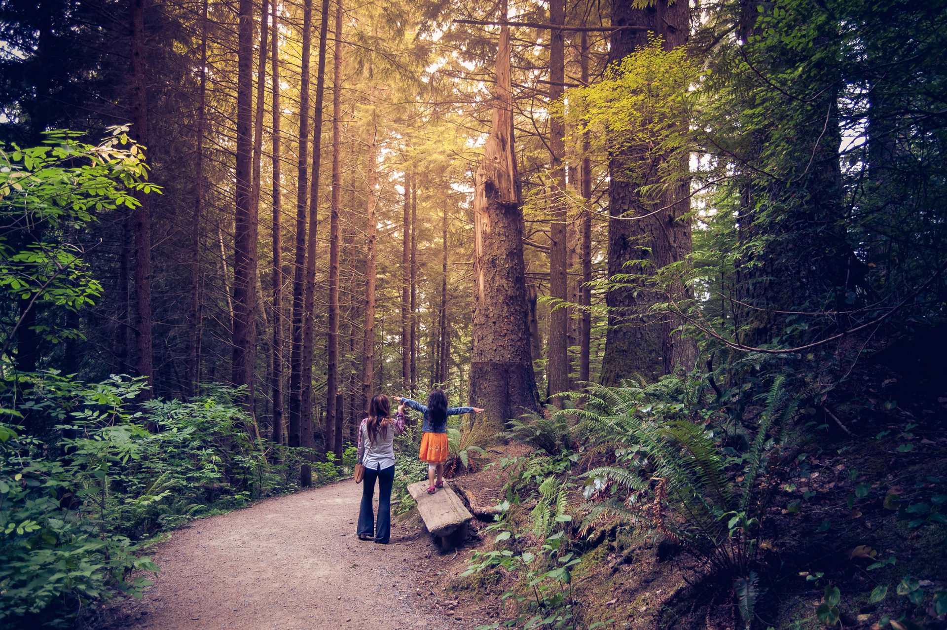 A mother and daughter enjoying a hike in a lush Oregon forest